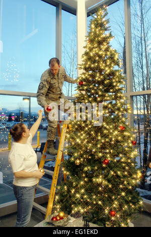 Stati Uniti Air Force Tech. Sgt. Valorie Floyd sinistra e Master Sgt. Paolo Hennig decorare un albero di vacanza nel foyer del Veterans Affairs Medical Center di Anchorage in Alaska,, 6 dicembre 2011. Floyd e Hennig sono assegnati per la Air Force Reserve 477th Fighter Group. Tech. Sgt. Dana Rosso Foto Stock