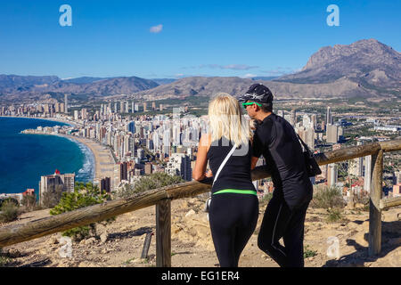 I turisti di indossare abbigliamento sportivo ammirando la vista di Benidorm, Costa Blanca, Spagna. Preso da chiudere dietro di loro. Foto Stock