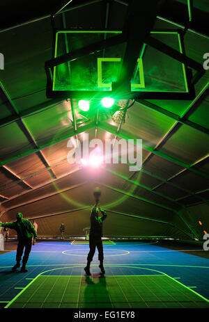 Stati Uniti Air Force Col. James Jacobson, la 376 Air Expeditionary Wing Commander, tenta un colpo dal free-linea di tiro all'interno di un nuovo centro fitness campo casa febbraio 13, 2012, durante la sua grande apertura al centro di transito di Manas, Kirghizistan. La casa di campo è il primo passo verso il revamping di centro fitness presso il centro di transito. Il personale Sgt. Angela Ruiz Foto Stock