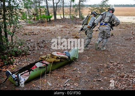 Stati Uniti Air Force delle forze di sicurezza membri tirare un aereo simulato crash vittima per la sicurezza 7 marzo 2012, durante il guerriero di smeraldo esercizio a Hurlburt Field, Fla. lo scopo primario del guerriero di Smeraldo è di esercitare le operazioni speciali componenti in ambiente urbano e guerra irregolare le impostazioni necessarie per supportare i comandanti combattente nelle campagne di teatro. Tech. Sgt. Charles Larkin Sr. Foto Stock