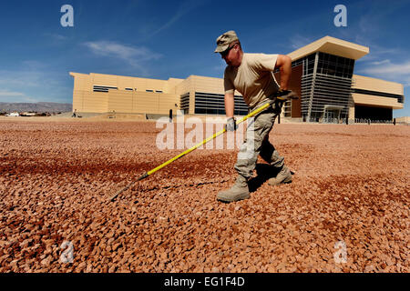 Stati Uniti Air Force Staff Sgt. Chris Wright si diffonde nella ghiaia per un xeriscape design presso il nuovo Warrior Fitness Center presso la Base Aerea Militare di Nellis Nev., Marzo 20, 2012. Xeriscaping è un modo per risparmiare acqua dal paesaggio in modi che riduce o elimina la necessità di utilizzare acqua per irrigazione. Wright è un 99th ingegnere civile Squadron marciapiede e costruzione artigiano. Il personale Sgt. William P.Coleman Foto Stock