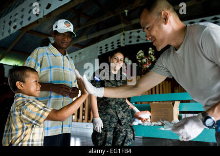 Stati Uniti Air Force Il Mag. Thai Le battendo il cinque un bambino honduregno dopo la somministrazione di de-cercando vermi medicazione durante l'unità più recenti della preparazione medica e di esercizio a Wawina, Honduras, 19 aprile 2012. In collaborazione con il Ministero dell Honduras di salute e militari honduregne, Joint Task Force-Bravo fornito assistenza medica ai pazienti 1,774 in Batalla e Wawina dal 18 aprile al 21. Le è il responsabile del JTF-Bravo elemento medico di medicina preventiva sezione. 1Lt. Christopher Diaz Foto Stock