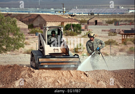 Stati Uniti Air Force Tech Sgt. Joshua Tully acque dello sporco verso il basso come un altro Airman attende di livello basso durante una missione di addestramento su una pista di atterraggio simulato il 26 aprile 2012, presso la Base Aerea Militare di Nellis Nev. Il cavallo rosso Engineering Team valuta gli aerodromi, elimina gli ostacoli, rende opportuno airfield le riparazioni dei danni, e fornisce una prima valutazione delle richieste di follow-su forze e risorse materiali per stabilire sostenibile Aviosuperficie di contingenza operazioni. Tully è un 820th cavallo rosso squadrone airborne flight vigile del fuoco. Il personale Sgt. Christopher Hubenthal Foto Stock