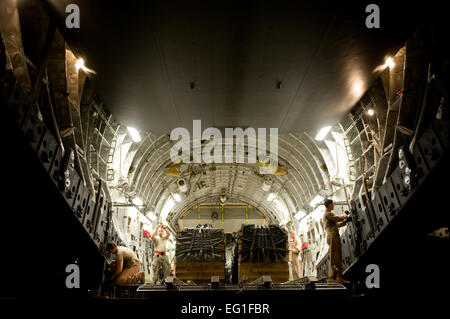 Stati Uniti Air Force loadmasters con il 816th Airlift Expeditionary Squadron, configurare un C-17 Globemaster III per un airdrop mentre un U.S. Esercito Comune di Airdrop rigger di ispezione con la 421st Quartermaster Company, trivelle linee statiche in una località segreta nel sud-ovest Asia, 4 maggio 2012. Il C-17 è uno dei due di rialimentazione dell'antenna le piattaforme utilizzate da parte del governo degli STATI UNITI Forze Aeree Aria Mobilità divisione. Nel 2011 il processore AMD diretto il gocciolamento di oltre 58,000 fasci comprendenti più di 80 milioni di sterline di forniture fondamentali al personale nel austero avamposti di combattimento. Foto Stock