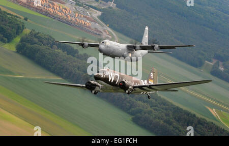 Un Douglas C-47 Skytrain, noto come Whiskey 7, vola a fianco di un C-130J Super Ercole dal 37th Airlift Squadron sulla Germania, 30 maggio 2014. Il C-47 è venuto a Ramstein per una settimana per partecipare ad attività di base con il suo gruppo di legacy, la trentasettesima Airlift Squadron, prima di ritornare in Normandia per ricreare il suo ruolo e lanciare paracadutisti oltre l'originale nella zona di caduta in Sainte-Mere Eglise, Francia. Il personale Sgt. Sara Keller Foto Stock