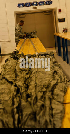 Stati Uniti Air Force Staff Sgt. Shamir Moore, 58th Rescue Squadron equipaggi di volo tecnico di apparecchiature, controlla il pack che consente di mettere in attesa una MC1-1D paracadute Giugno 24, 2013, presso la Base Aerea Militare di Nellis Nev. L'equipaggio di volo aviatori attrezzatura supporta il pararescuemen del 58th RQS. Senior Airman Daniel Hughes Foto Stock