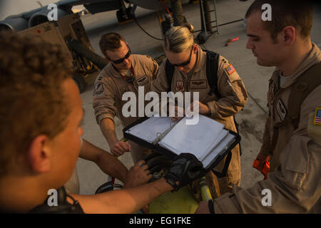 Capitani Andrea Delosreyes e Trento Parker e Airman 1. Classe Kevin Hagghith, 340 Expeditionary Air Refuelling Squadron, KC-135 Stratotanker piloti e boom operatore, discutere un pre-lista di controllo di volo con i manutentori del 340 Manutenzione aeromobili squadrone prima di un rifornimento di aria la missione in Iraq, 11 Agosto, 2014. L'equipaggio è programmato per scaricare più di 40.000 galloni di combustibile F-16 Fighting Falcons completando missioni in Iraq. Il personale Sgt. Vernon giovani Jr. Foto Stock