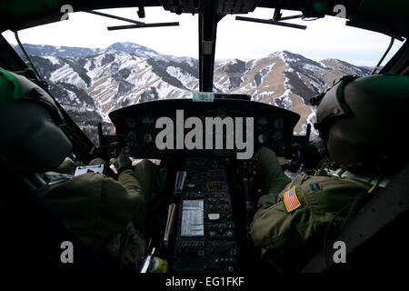 Primo Lt. Greg Johnston e il cap. RJ Bergman volare loro UH-1N Iroquois su una catena montuosa Gen 27, 2015, vicino a Malmstrom Air Force Base, Mont. Il volo ha avuto l'equipaggio su una varietà di terreno e altitudini, dalla pianura alle valli e montagne. Entrambi gli avieri sono quarantesimo elicottero squadrone di piloti di salvataggio. Airman 1. Classe Dillon Johnston Foto Stock