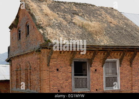 Tradizionale stile newar-rosso mattone-tegole del tetto cosparsi di erba-vecchia casa con arcate cieche e windows nell'area della città vecchia. Foto Stock