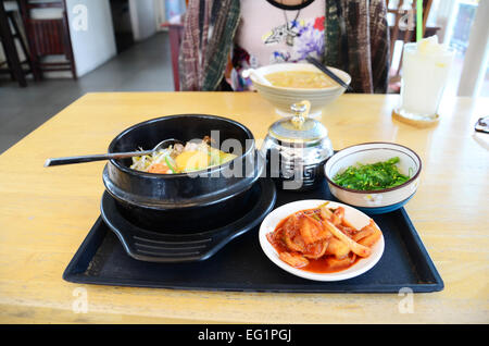 Cibo coreano impostare Bibimbub con cavolo Cinese e Giapponese insalata di alghe marine in una calda tazza di pietra e il piatto laterale Foto Stock