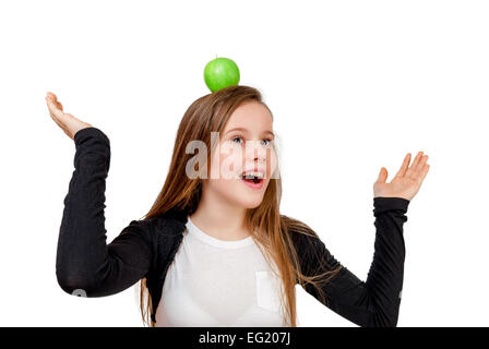 Bambina con mela verde sulla testa isolata su bianco Foto Stock