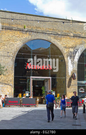 La gente a piedi passato Nando's restaurant in Clink Street, Southwark Foto Stock