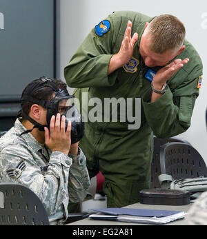 Stati Uniti Air Force Senior Airman Abimael Santiago, sinistra e Senior Master Sgt. Mike verde, entrambi gli ingegneri di volo con il nono Airlift Squadron, lavorare insieme durante la maschera di chimica sessione di un biologico chimiche radioattive e nucleari survival skills training class Agosto 9, 2012, alla Dover Air Force Base, Del. il 436th ingegnere civile squadrone di gestione delle emergenze e la sezione di addestramento fornito corsi di formazione per tutti attivi-dovere personale. Roland Balik Foto Stock