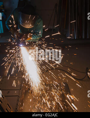 Il personale Sgt. Zachary Arbuckle taglia attraverso un foglio di metallo usando un plasma cutter Maggio 14, 2013, a Yokota Air Base, Giappone. La punta di un coltello al plasma è in grado di raggiungere temperature di 25.000 gradi Fahrenheit. Il Plasma Cutter è in grado di tagliare attraverso i diversi metalli e spessori a seconda del suo rating. Quello che si vede qui è in grado di tagliare attraverso un pollice di acciaio. Arbuckle è un aeromobile metalli artigiano tecnologia assegnato al 374 Squadrone di manutenzione. Senior Airman Michael Washburn Foto Stock