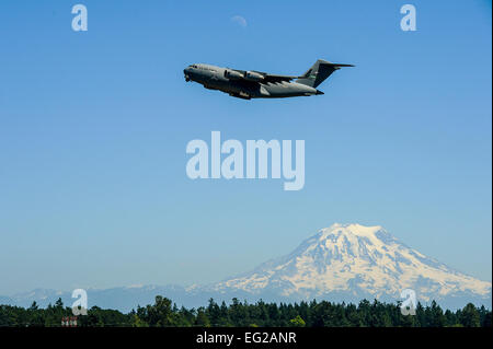 Una C-17 Globemaster III ascende al di sopra del giunto di base corda Lewis-Mc, nello Stato di Washington, come il Monte Rainier torri nella distanza Luglio 15, 2013. Il C-17 pilotato da Col. Wyn sambuco, stava eseguendo un touch and go prima del suo approccio finale. Tech. Sgt. Sean Tobin Foto Stock