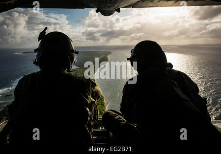 Senior Airman Timothy Oberman sinistra e Staff Sgt. Nick Alarcon guardare fuori il retro di un C-130H Hercules dopo la caduta del primo pallet di beni umanitari all'isola di Ulal, Dic 11, 2012. Operazione di caduta di Natale è una organizzazione non-profit alimentato da volontari di Andersen Air Force Base e la locale comunità di Guam. Oberman e Alarcon sono loadmasters con la trentaseiesima Airlift Squadron, Yokota Air Base, Giappone. Tech. Sgt. Samuel Morse Foto Stock