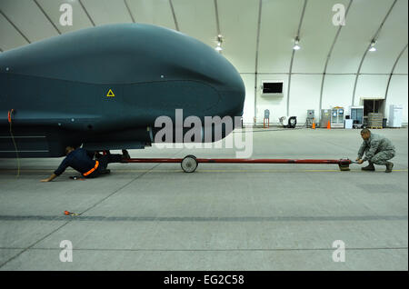 Senior Airman Blaine Aponte e Staff Sgt. Juan Lopez rimuovere una barra di traino da un RQ-4 Global Hawk prima di effettuare le operazioni di manutenzione il 15 aprile 2014, nel sud-ovest Asia. Il Global Hawk fornisce intelligence, sorveglianza e ricognizione e di capacità di comunicazioni su Asia sud-ovest. Aponte e Lopez sono membri del 380 Expeditionary Manutenzione aeromobili squadrone. Tech. Sgt. Russ Scalf Foto Stock