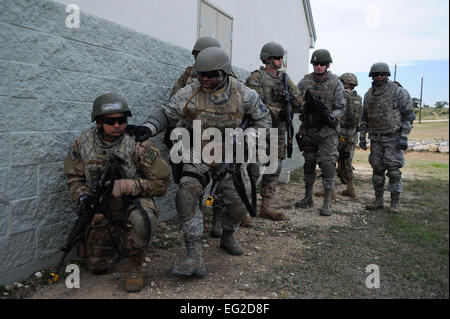 La lotta contro gli avieri la formazione di competenze agli studenti di prendere la copertura dietro un edificio durante un urbano esercizio delle operazioni alla base comune San Antonio-Camp Bullis, Texas, nov. 14, 2013. Il cast è un corso progettato da aria di istruzione e di formazione comando per standardizzare la pre-deployment Combat training per il personale dell'Air Force. Airman 1. Classe David R. Cooper Foto Stock