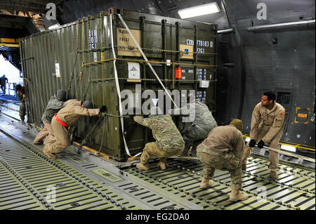 Avieri e soldati spingere un carico pallet treno su un C-5M Super Galaxy Gen 28, 2013, a Camp Marmal nel nord dell'Afghanistan. Il velivolo è assegnato alla 436th Airlift Wing alla Dover Air Force Base, Del. ed è attualmente implementato in avanti per assistere con la rotazione di due Stati Uniti Aviazione esercito task force. Tech. Sgt. Parker Gyokeres Foto Stock