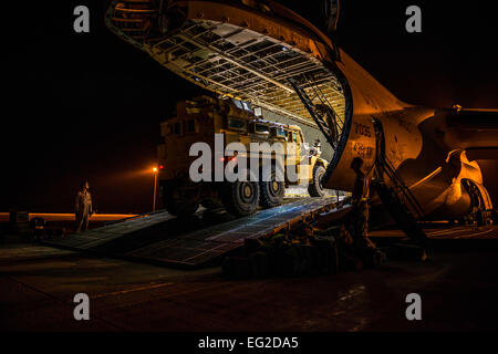 Avieri con il nono Airlift Squadron e 455th Expeditionary porta antenna squadrone con Marines dal Marine Expeditionary Brigade preparare per caricare veicoli in un C-5M Super Galaxy 6 ott. 2014, a Camp Bastion, Afghanistan. Avieri e Marines caricato più di 266,000 libbre di carico sul C-5M come parte delle operazioni retrogrado in Afghanistan. Il personale Sgt. Jeremy Bowcock Foto Stock