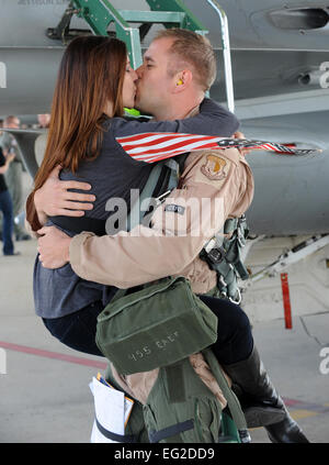 Erri Bandy ottiene un abbraccio ed un bacio da suo marito, il cap. Aaron Bandy, come egli passi fuori dalla scaletta del suo F-16 Fighting Falcon 15 aprile 2011, a Hill Air Force Base in Utah, dopo il ritorno dall'Afghanistan. Capitano Bandy è un pilota assegnato al 4° Fighter Squadron. Alex R. Lloyd Foto Stock