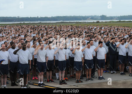 Avieri da Keesler Air Force Base, Miss., rendere un omaggio durante l'inno nazionale prima di iniziare a 5K eseguire sulla linea di volo sett. 19, 2014. La corsa è stata il calcio di inizio evento per una giornata piena di attività a supporto della giornata wingman. Kemberly Groue Foto Stock