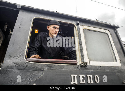 Il driver di una vecchia locomotiva a vapore. Xiv Feb, 2015. -- Febbraio 14th. 2015 Kiev Central Station per anello ferroviario nel suo straordinario volo è andato un preferito con molte persone di Kiev e gli ospiti retrò treno. Vecchia locomotiva a vapore guidato lentamente intorno alla capitale dell'Ucraina. © Igor Golovniov/ZUMA filo/Alamy Live News Foto Stock