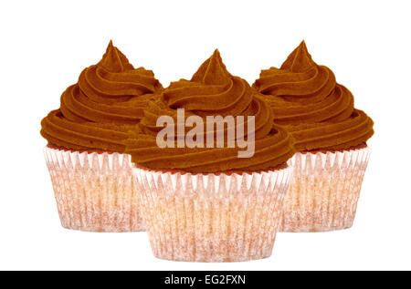 Tre tortini di cioccolato con volute di glassa, isolato su uno sfondo bianco Foto Stock