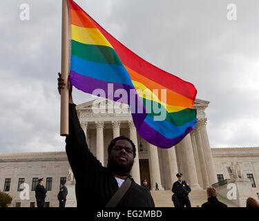 Afro-americano di uomo sventola bandiera arcobaleno davanti alla Corte suprema degli Stati Uniti edificio - Washington DC, Stati Uniti d'America Foto Stock