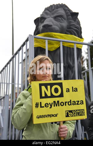 Madrid, Spagna. Xiv Feb, 2015. Attivista di Greenpeace con un banner contro la legge di Gag (cittadino il diritto di protezione) e una scultura di un imbavagliato lion durante una manifestazione a Madrid contro il cittadino spagnolo del diritto di protezione. Credito: Marcos del Mazo/Alamy Live News Foto Stock