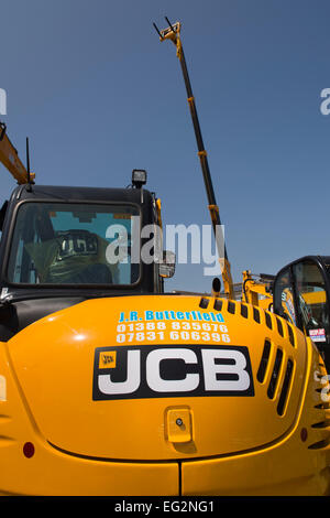 Sotto il profondo blu del cielo, vista ravvicinata di pulire luminoso giallo JCB 8085 escavatore Midi parcheggiato sul display - stand commerciali, grande spettacolo dello Yorkshire, Inghilterra, Regno Unito. Foto Stock