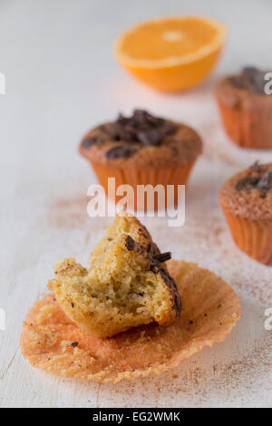 Mezze mangiate e arancione scuro muffin al cioccolato Foto Stock