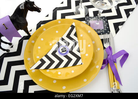 Corse di cavalli Carnevale evento pranzo luogo tabella di impostazione in viola, tema di colore giallo e bianco e nero Nastro chevron tabella runner Foto Stock