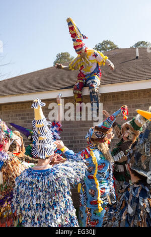 I festaioli la cattura di un partecipante saltando fuori da un tetto durante il tradizionale Cajun Courir de Mardi Gras Febbraio 14, 2015 in Elton, Louisiana. I festaioli vanno di casa in casa a mendicare per raccogliere cibo per un pasto comune e da celebrare la danza per gli astanti quando hanno successo. Capitaines andare a cavallo tenta di controllare il buon natured buontemponi come essi romp attraverso la campagna causando il male. Foto Stock