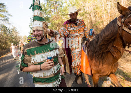 La Capitaine cerca di controllare un partecipante mascherato durante il tradizionale Cajun Courir de Mardi Gras Febbraio 14, 2015 in Elton, Louisiana. I festaioli vanno di casa in casa a mendicare per raccogliere cibo per un pasto comune e da celebrare la danza per gli astanti quando hanno successo. Capitaines andare a cavallo tenta di controllare il buon natured buontemponi come essi romp attraverso la campagna causando il male. Foto Stock