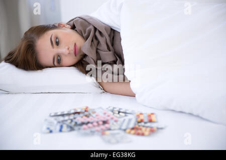 Malati giovane donna in appoggio nel letto di casa Foto Stock