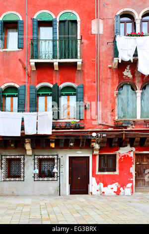 Vecchia casa rossa witn biancheria da essiccazione a Venezia, Italia Foto Stock