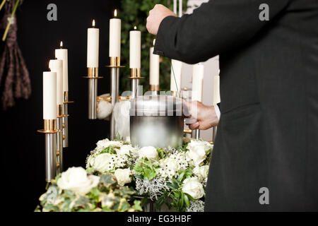 La religione, la morte e il dolor - mortician sul funerale con urna Foto Stock