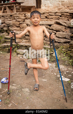 Giovane ragazzo nepalese e pali trekking Foto Stock