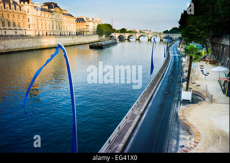 Senna e Paris Plage - Un estate spiaggia accanto al fiume. Barge in movimento sul fiume vicino a ponte. Parigi, Francia. Foto Stock