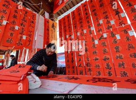 Fuzhou, la Cina della provincia del Fujian. Xvi Feb, 2015. Un calligrafo scrive il Festival di Primavera di pergamene di Fuzhou, capitale del sud-est della Cina di provincia del Fujian, Feb 16, 2015. Il cinese inizierà a celebrare il capodanno lunare, o la festa di primavera nel febbraio 19. © Zhang Guojun/Xinhua/Alamy Live News Foto Stock