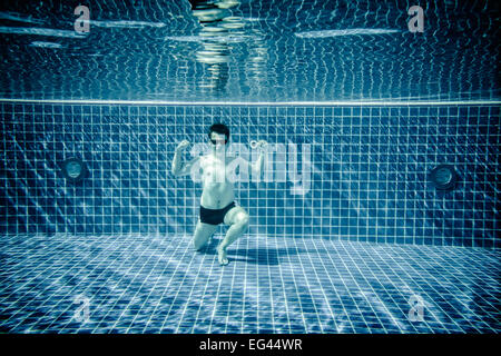 Uomo in posa come Superman piscina sottacqua Foto Stock