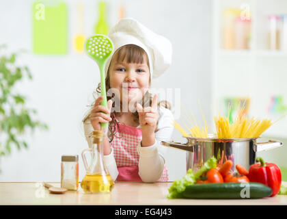 Kid cuoco rende sani pasto di verdura in cucina Foto Stock