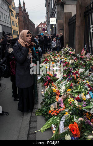 Copenhagen, Danimarca. Il 16 febbraio, 2015. Una giovane donna musulmana guardando i fiori nella parte anteriore del syunagogue ebraica in Copenhagen. Credito: OJPHOTOS/Alamy Live News Foto Stock