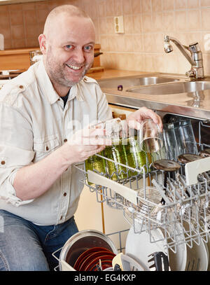 Homeworks, uomo sorridente per riempire la lavastoviglie Foto Stock
