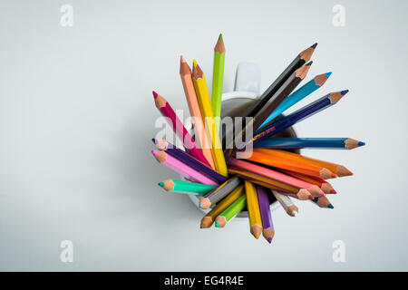 Un gruppo di matite di colore in una tazza da un angolo alto in un bianco sfondo isolato Foto Stock