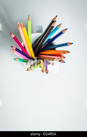 Un gruppo di matite di colore in una tazza da un angolo alto in un bianco sfondo isolato Foto Stock