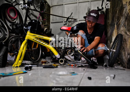 Una bicicletta meccanico assembla un custom made bike in un'officina di biciclette in Cali, Colombia. Foto Stock