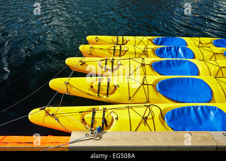 Giallo canoe e kayak , 5 pezzi, sono in acqua attaccato alla riva, avvolta , legato una corda per il castello , intorno al wat Foto Stock