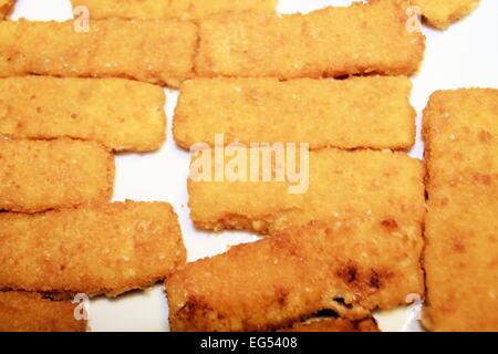 Bastoncini di pesce impanati nella piastra Foto Stock